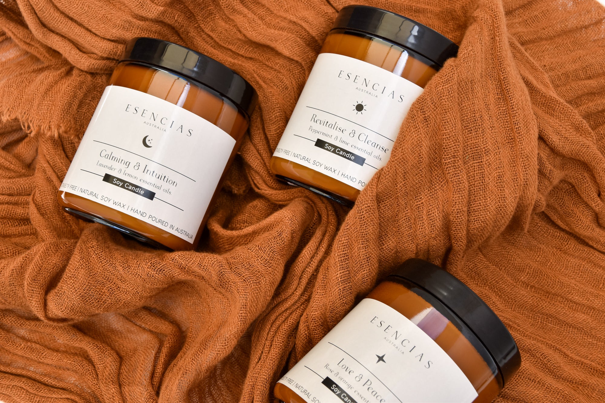 Calming and Intuition, Revitalise and Cleanse, and Love and Peace soy candles displayed together in a clean, product-focused image, showcasing their elegant amber jars and unique energetic offerings.