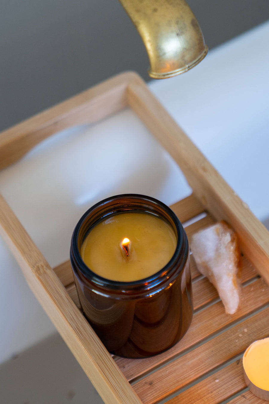 Revitalise and Cleanse candle with Citrine crystal styled in a bath setting, evoking clarity, renewal and uplifting energy.