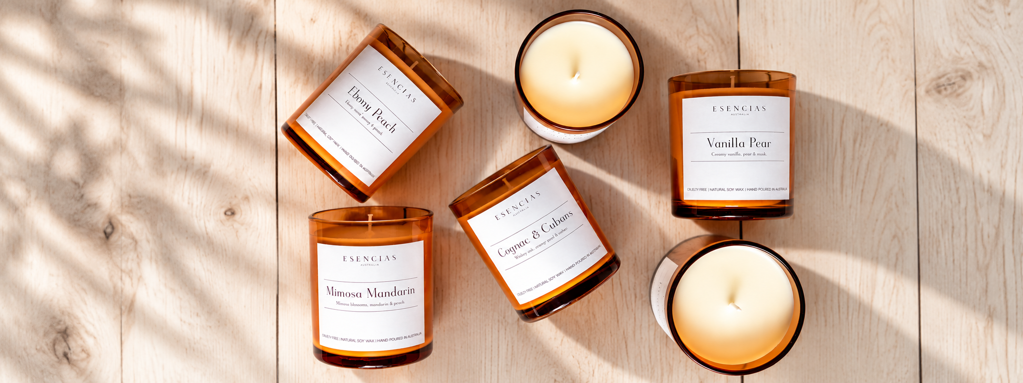 Collection of Esencias amber soy candles on light wood