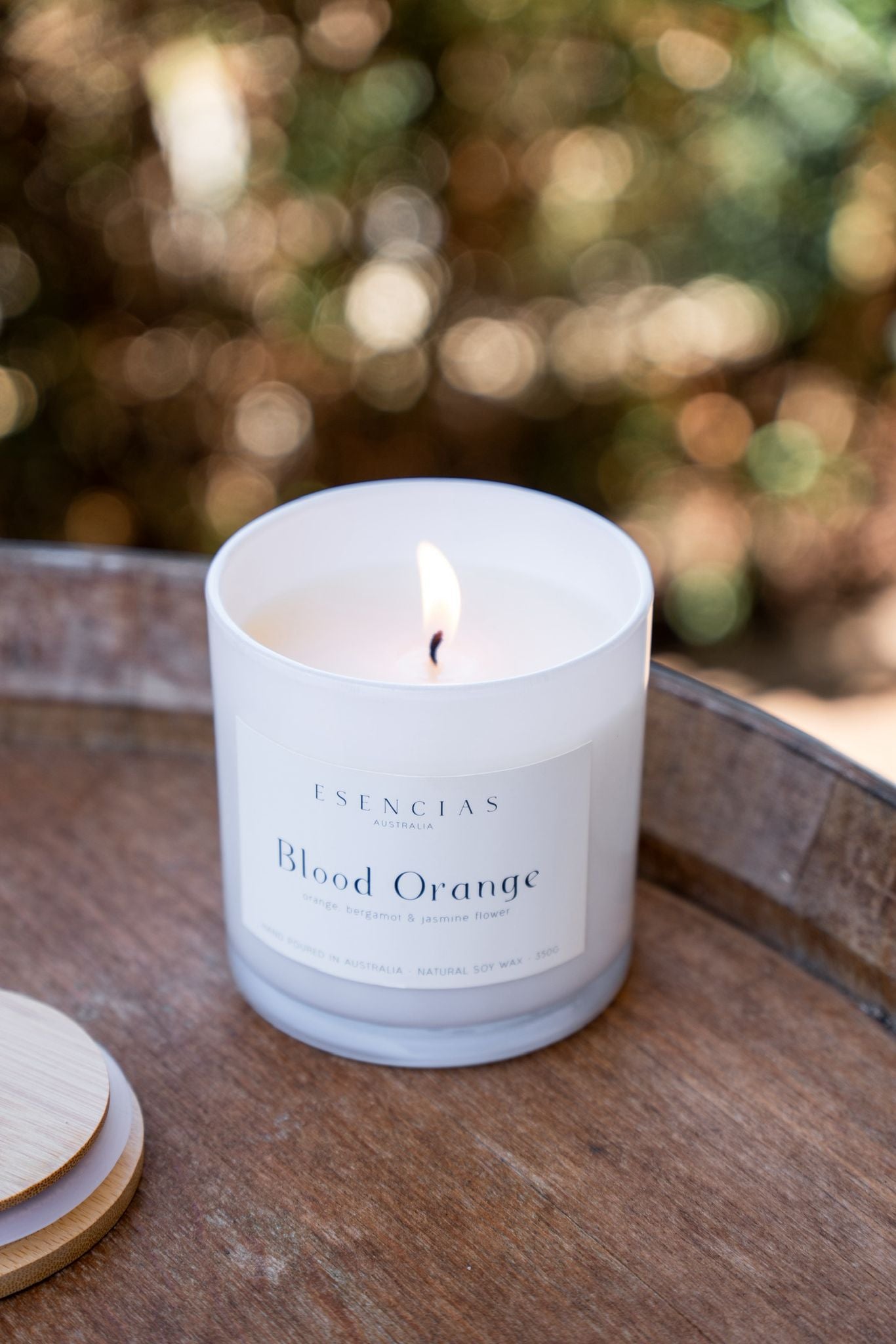 Blood Orange candle in white Coastal Collection jar styled on rustic wine barrel