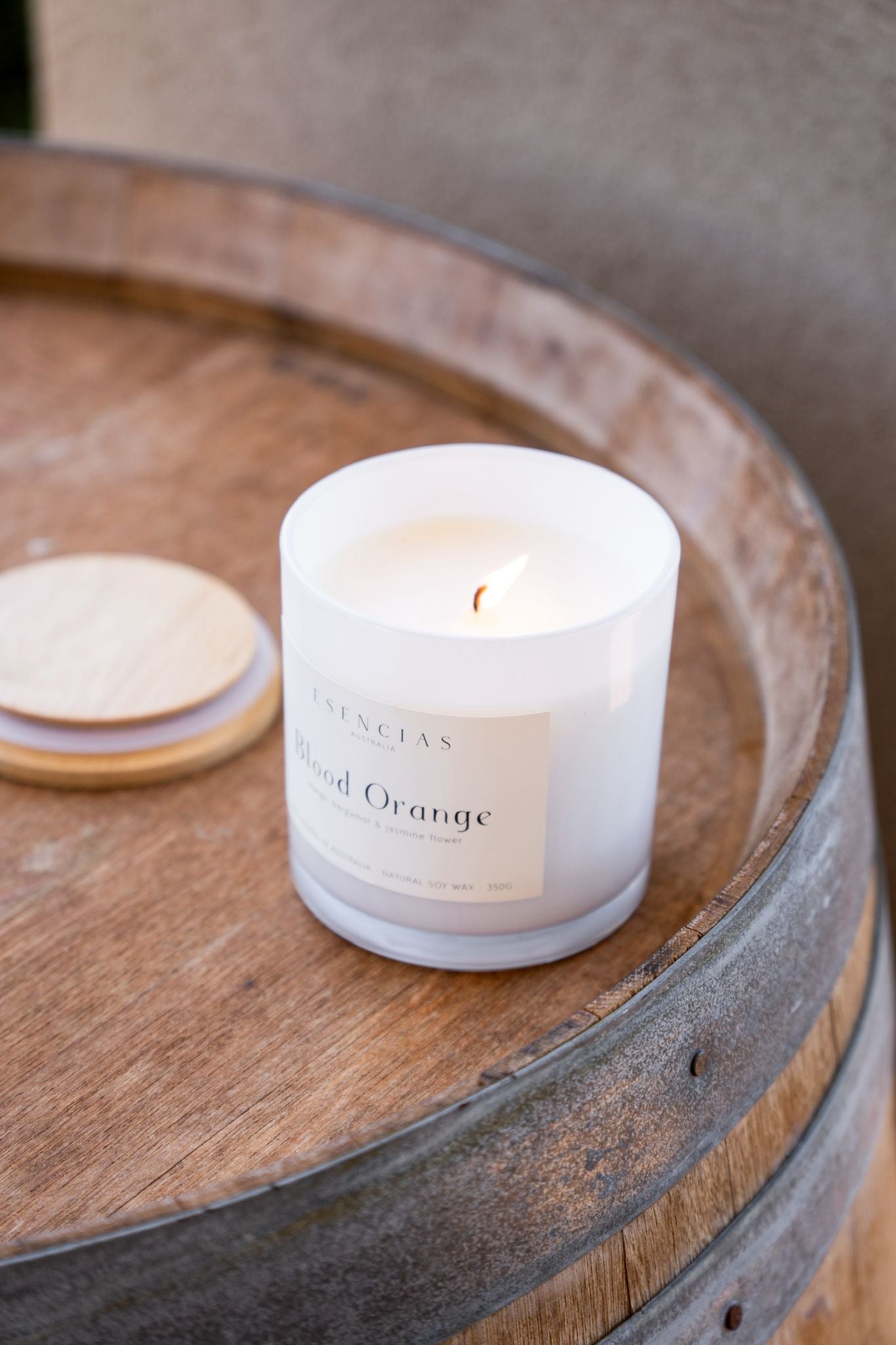 Close up on Blood Orange Coastal Collection candle on wooden barrel 