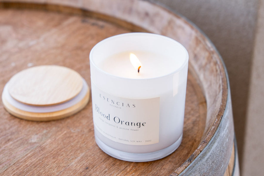 Rustic styled Blood Orange Coastal Collection candle on wine barrel 