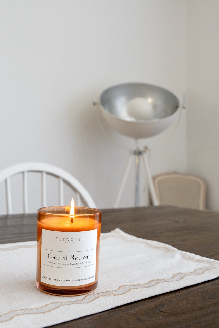 Coastal Retreat Soy Candle Signature Range styled inside on table with flame flickering 