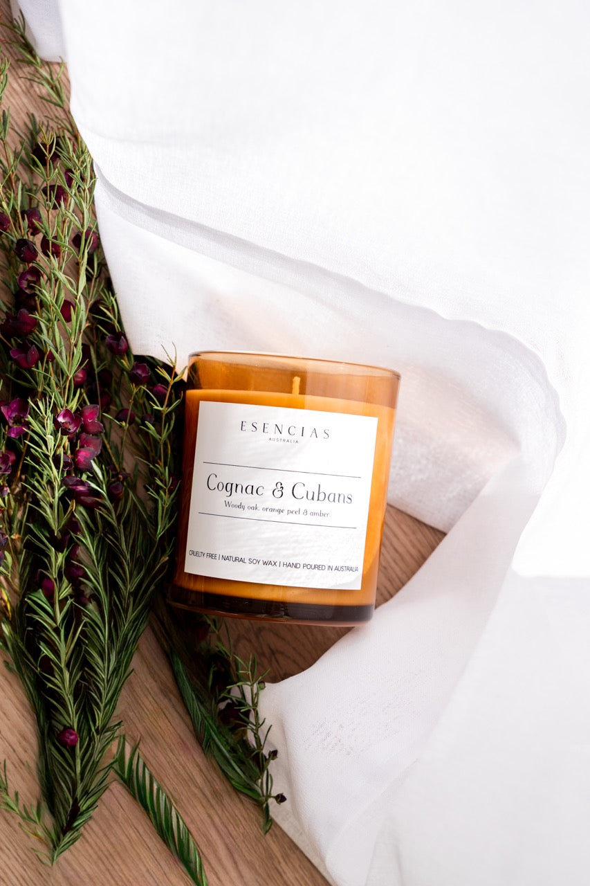 Cognac & Cubans Soy Candle Signature Range product shot of candle styled with flowers and timber/white background. 