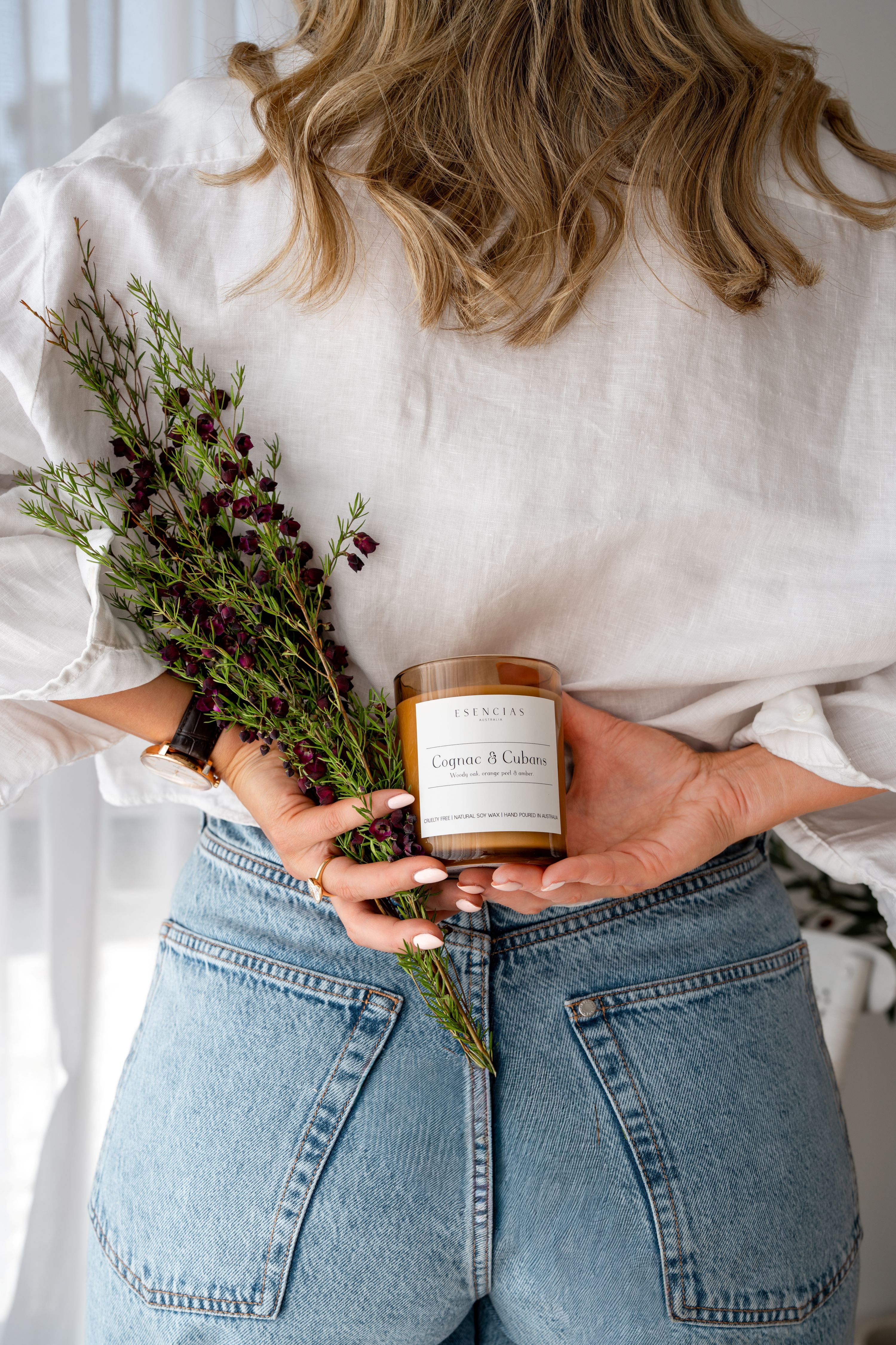 Dominique holding a cognac and cubans candle and a bouquet of flowers