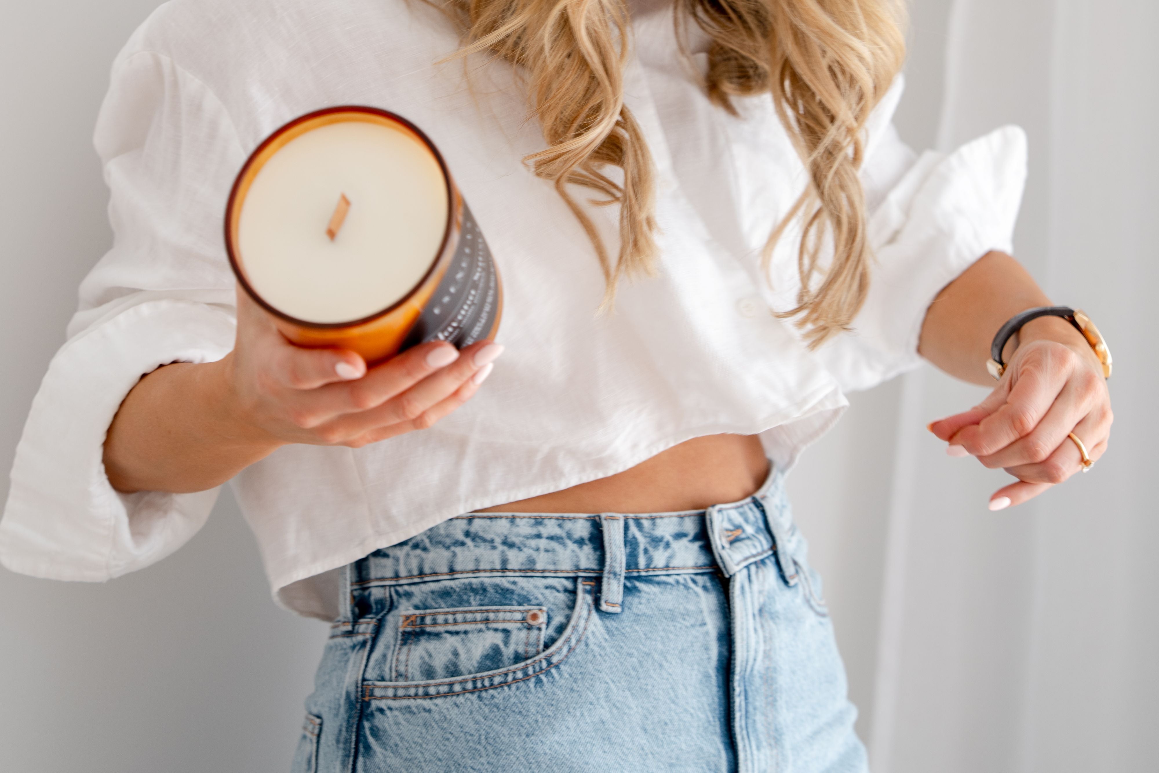 Playful shot of Dominique holding Esencias Luxe Candle 
