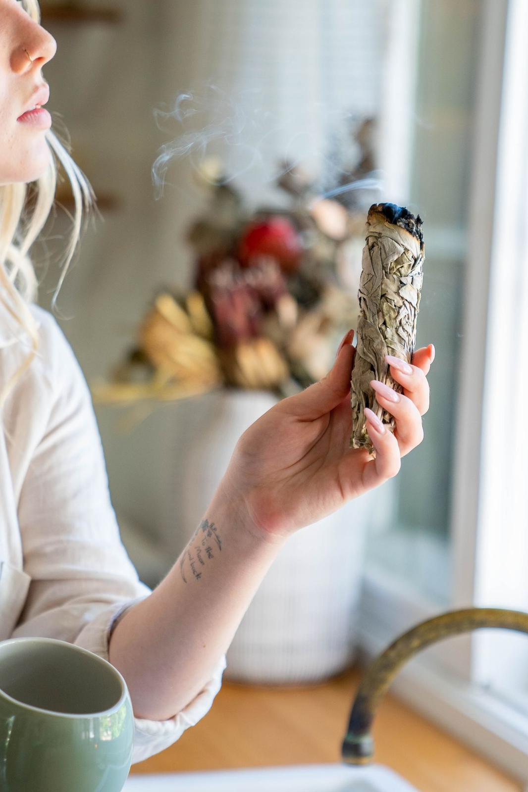 Blonde model with our Sage smudge stick in lifestyle shot. 