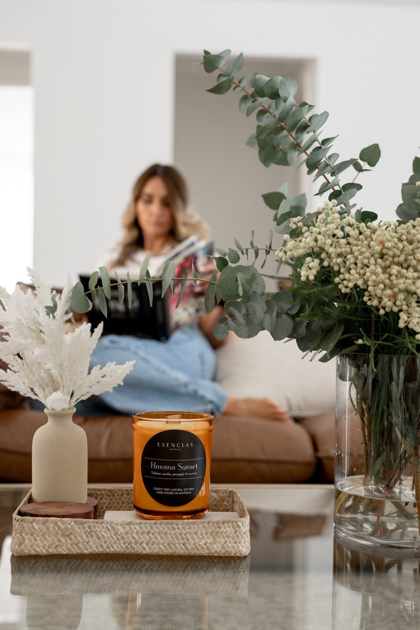 Signature Luxe Candle in Havana Sunset styled with plants and owner of Esencias