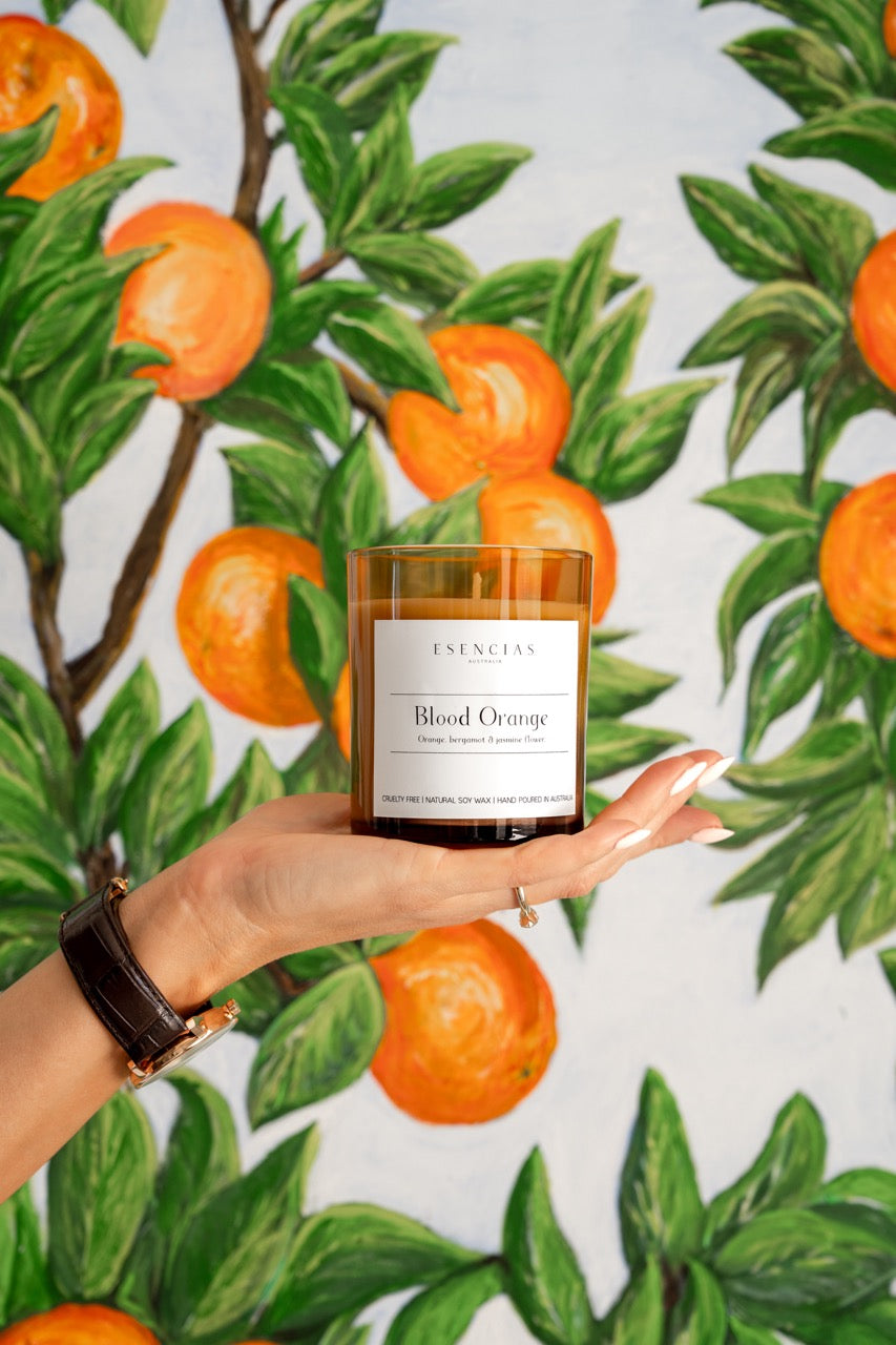 Signature Soy Candle Blood Orange in model shot with hand. 