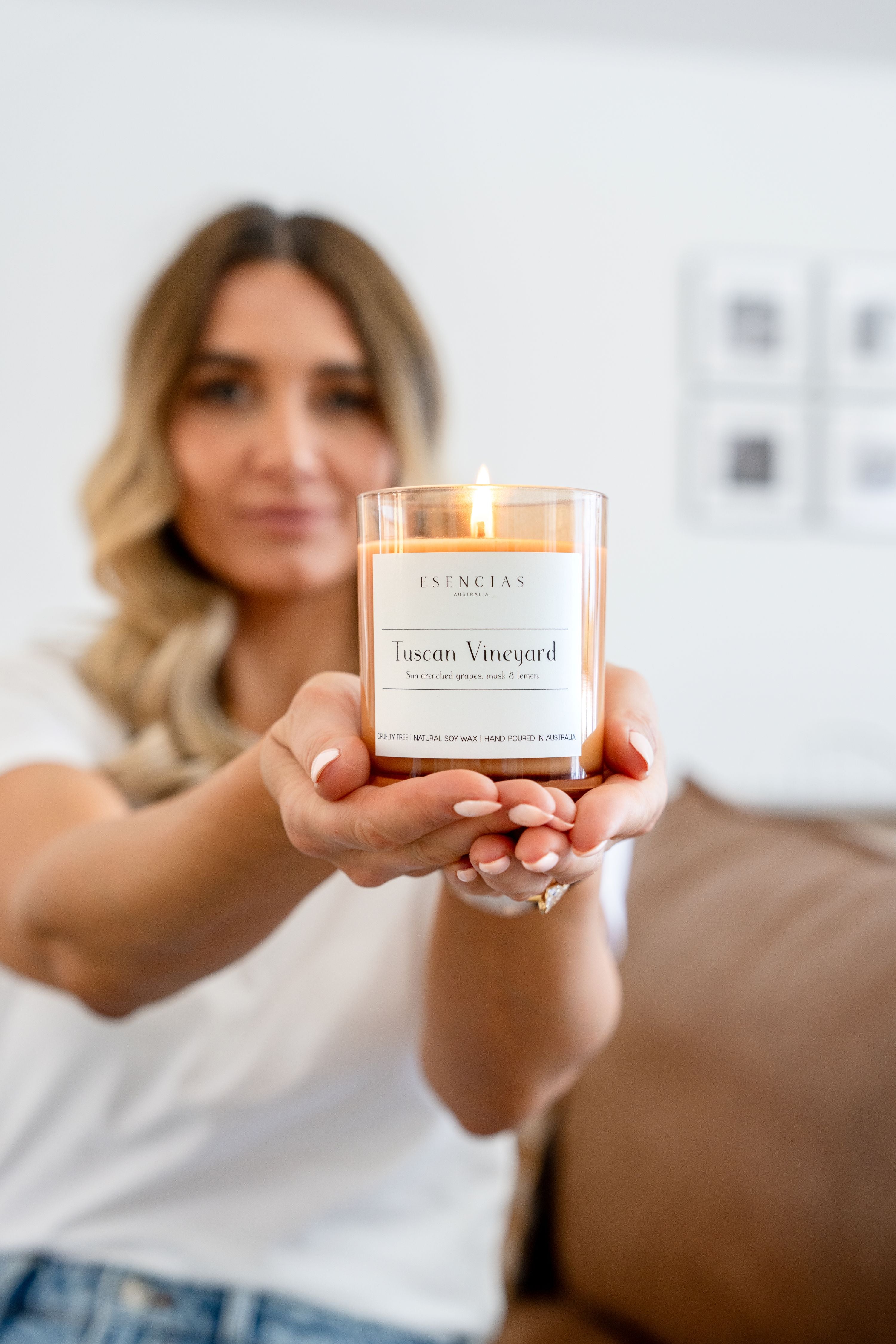 Our Signature Range Tuscan Vineyard Soy Candle held in a model shot by Esencias Founder, Dominique. 