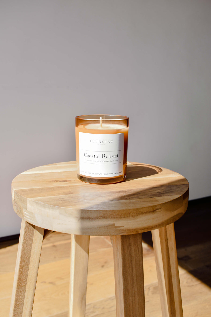 Coastal Retreat signature amber jar candle styled in a relaxed lifestyle setting, capturing warm, natural coastal vibes.