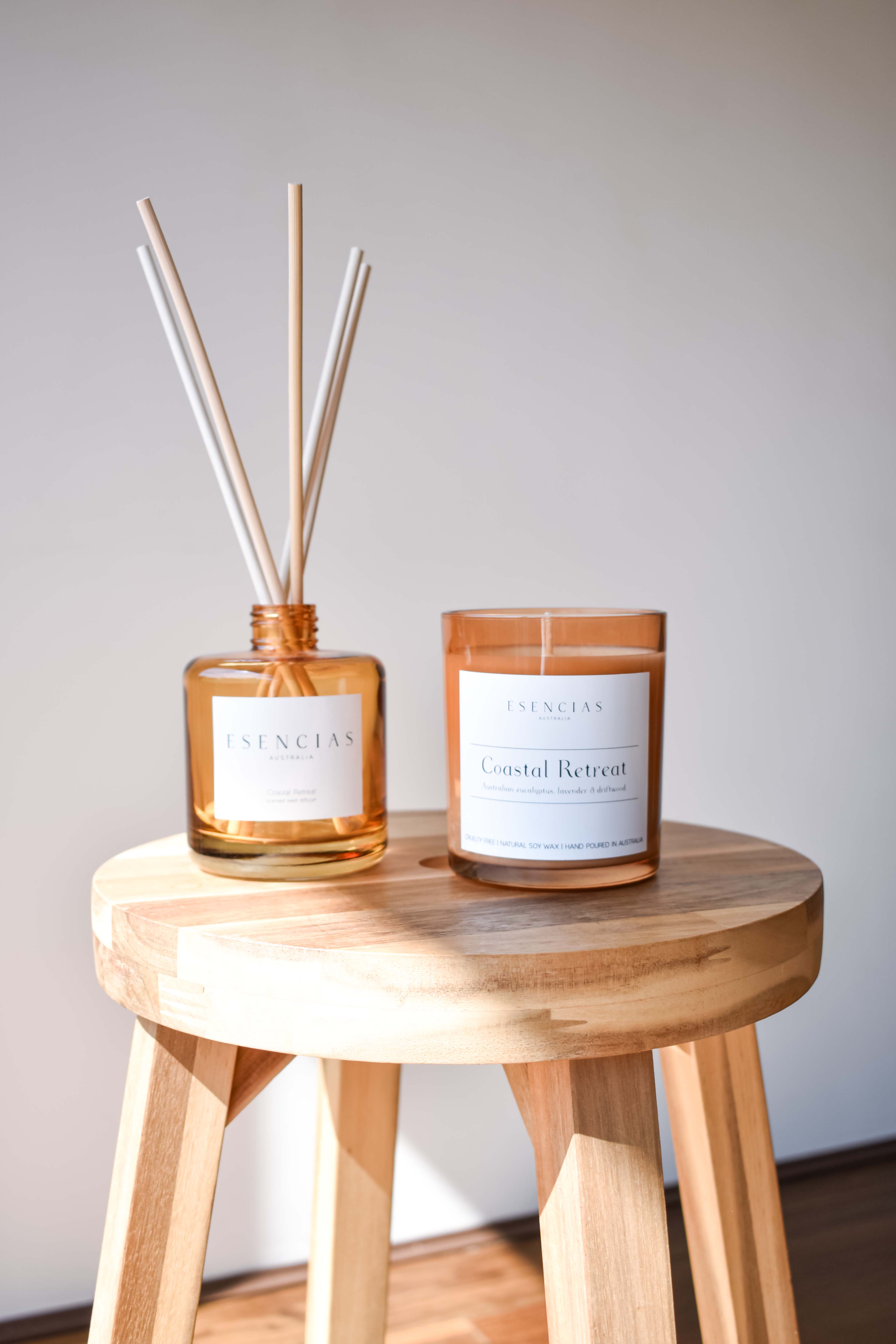 Coastal Retreat candle and reed diffuser in signature amber glass, styled to reflect warm, earthy tones and coastal elegance.