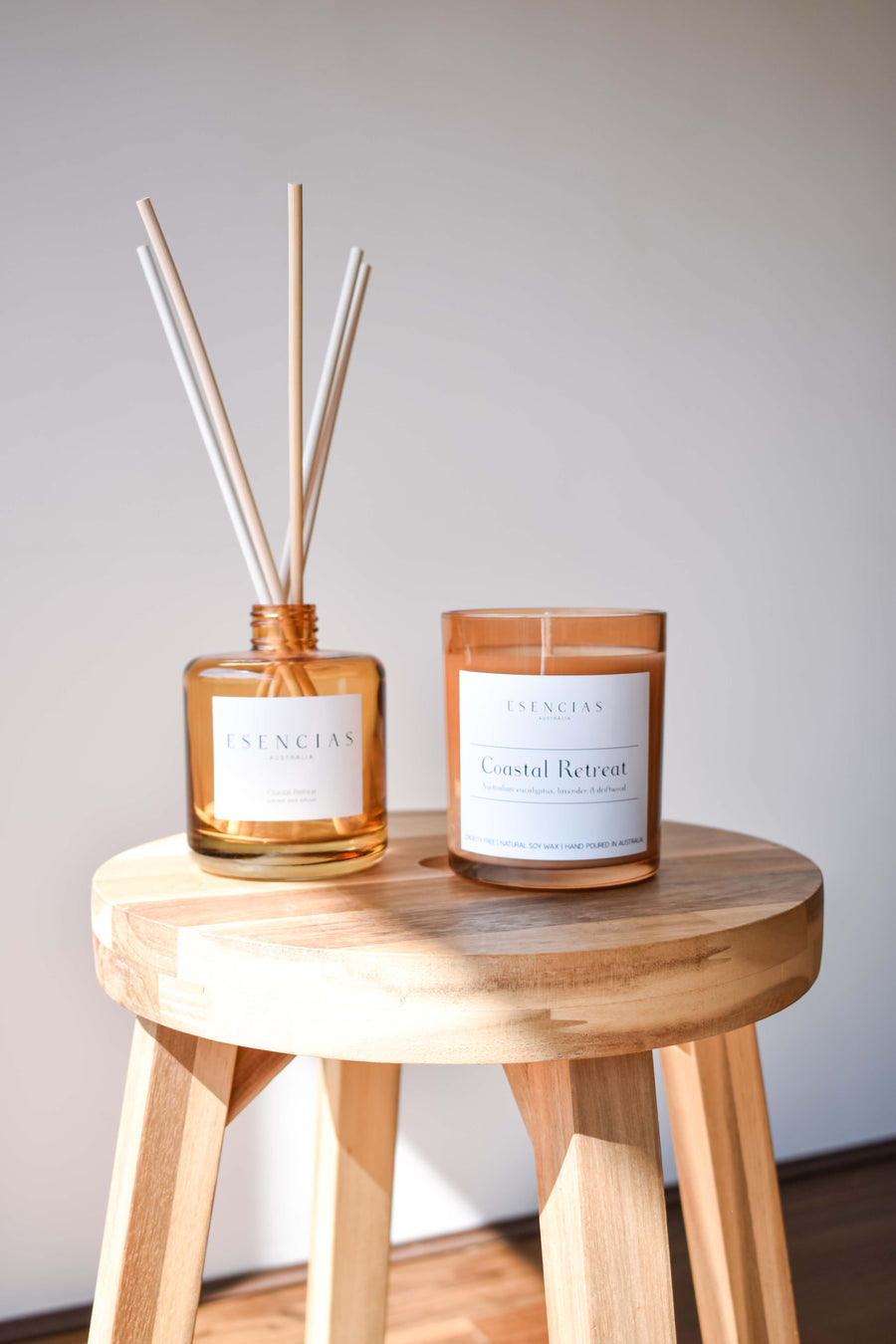 Coastal Retreat candle and reed diffuser in signature amber glass, styled to reflect warm, earthy tones and coastal elegance.