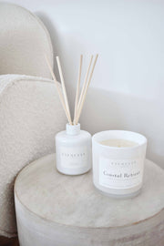 Coastal Retreat soy candle and reed diffuser styled together in a calming lifestyle setting, evoking a serene coastal atmosphere.