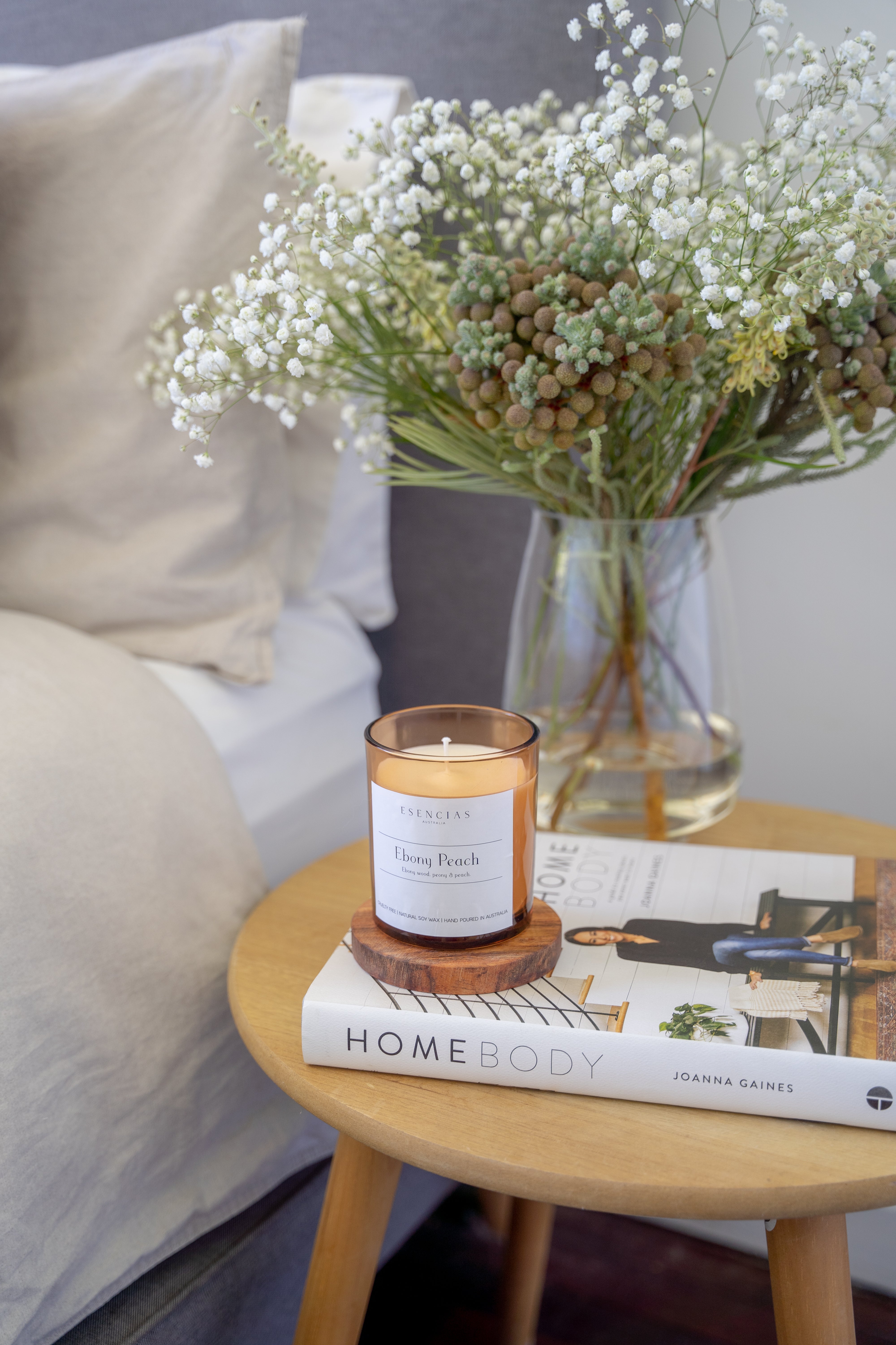 Ebony Peach signature amber candle styled on a bedroom table in a lifestyle setting, creating a cozy and elegant atmosphere.