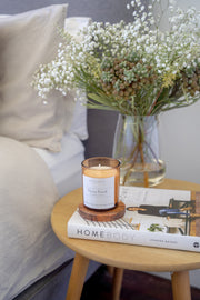 Ebony Peach signature amber candle styled on a bedroom table in a lifestyle setting, creating a cozy and elegant atmosphere.
