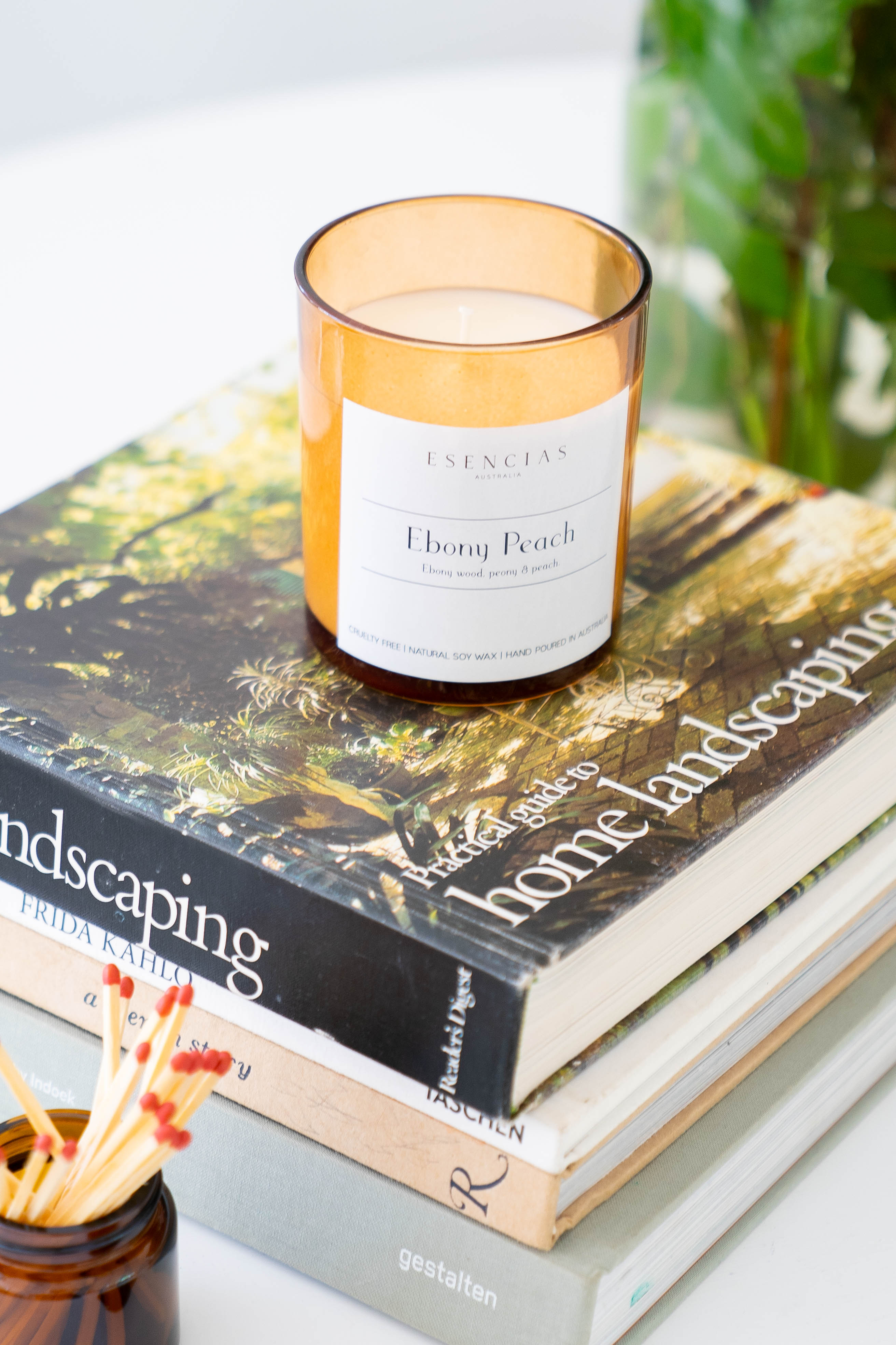 Ebony Peach candle in amber jar styled in a lifestyle setting, evoking warm, coastal-inspired tranquility.