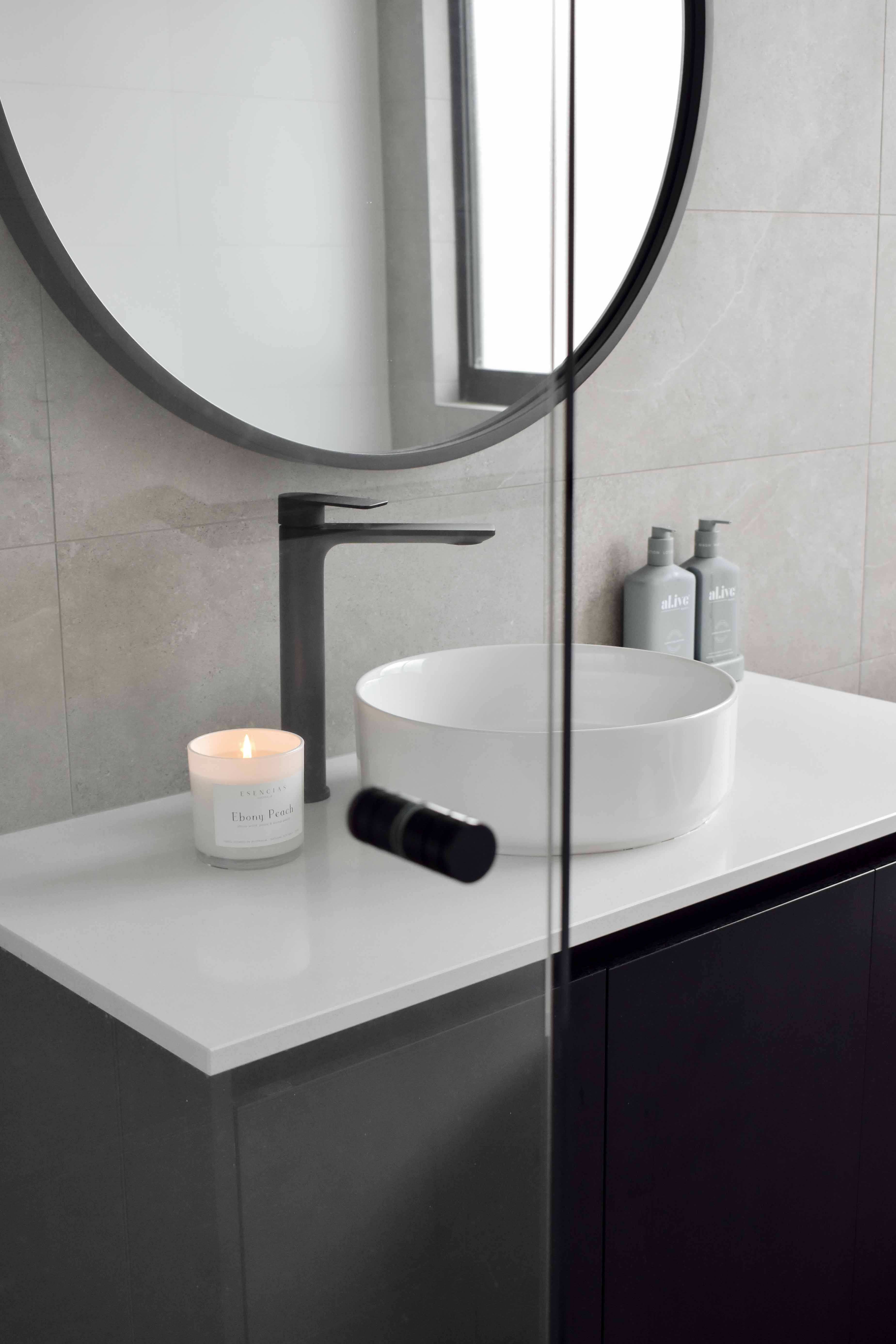 Ebony Peach Coastal Collection candle in white jar styled in a bathroom lifestyle setting, evoking fresh, clean and serene coastal vibes.