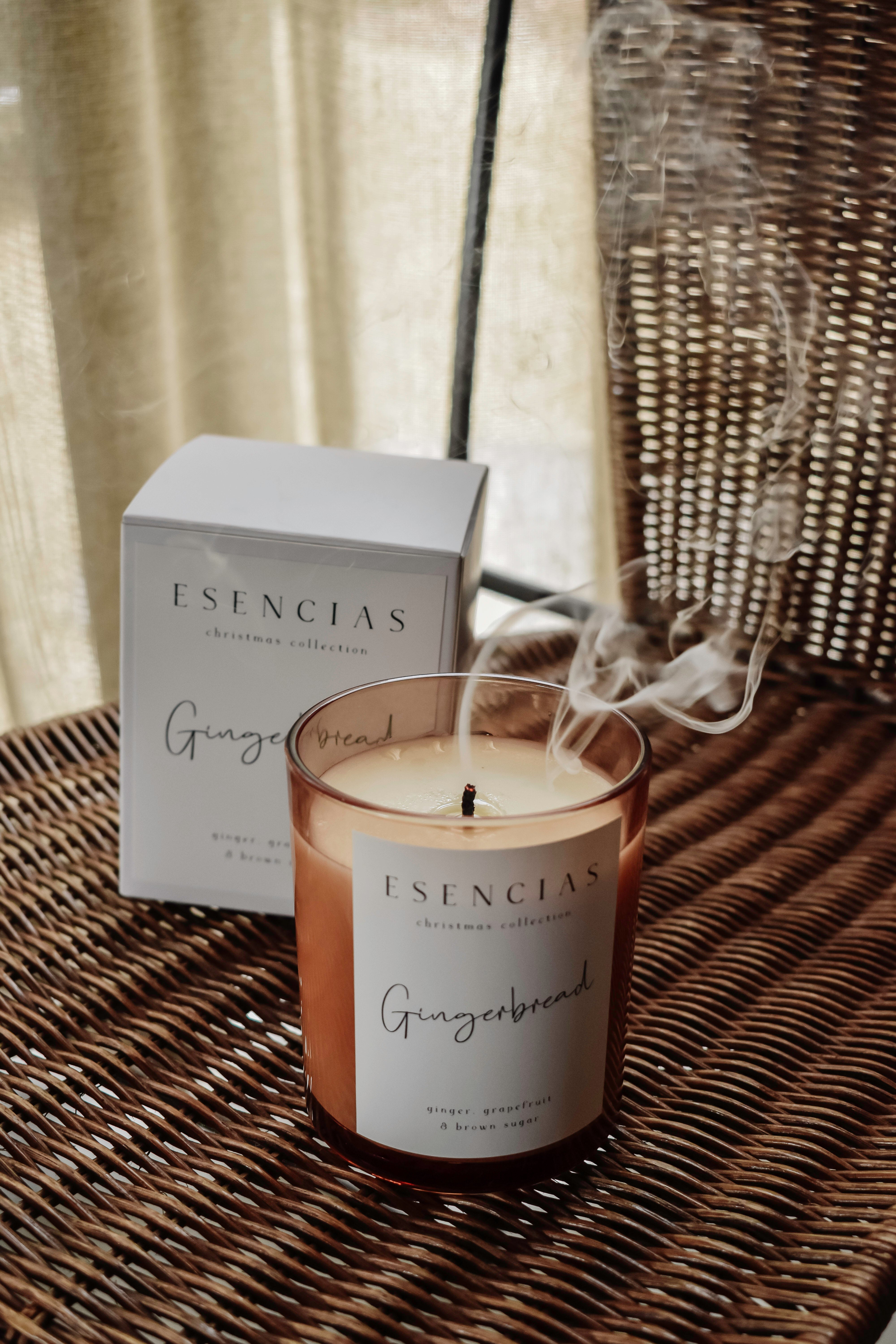 Gingerbread soy candle just blown out with smoke swirling in a calm lifestyle moment, capturing the essence of slow living.
