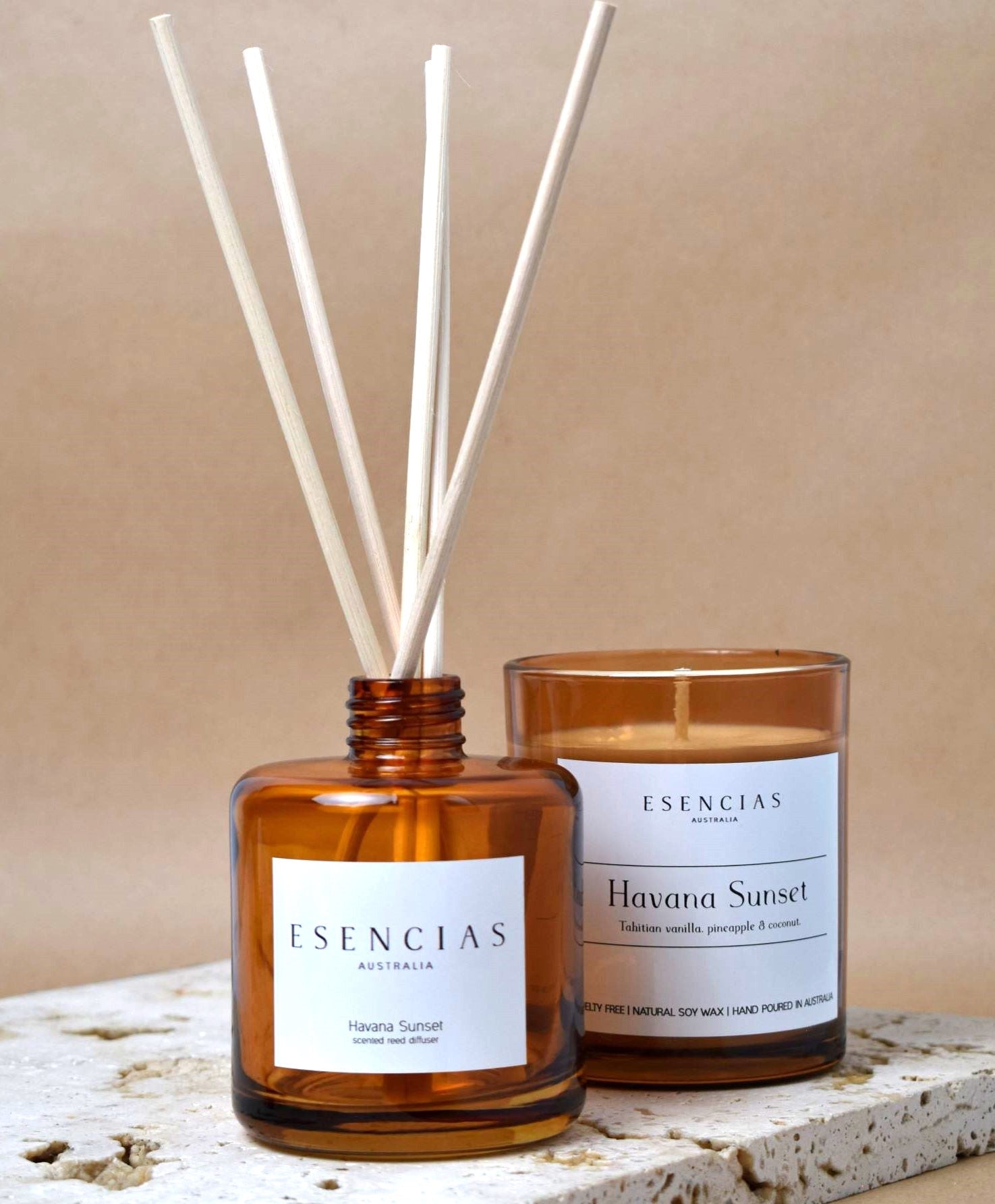 Havana Sunset candle and reed diffuser displayed in a bathroom setting with a product-focused composition, highlighting their sleek design and warm amber tones.