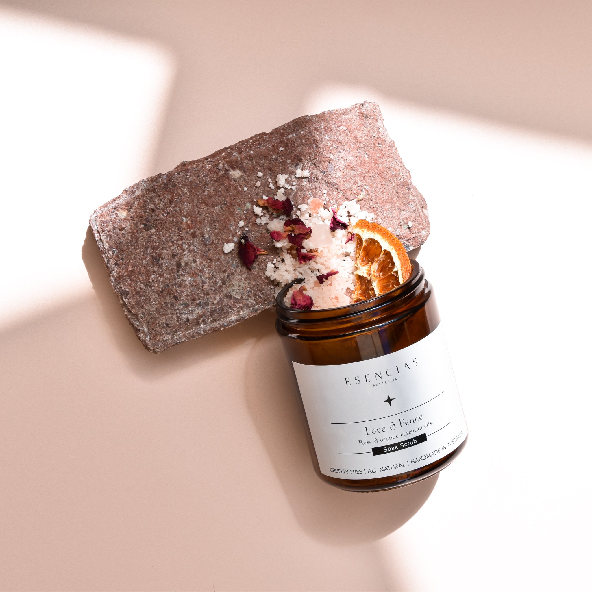 Love and Peace soak scrub jar spilled to reveal contents, shown in a product-focused image highlighting texture and natural ingredients.