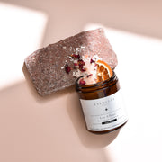 Love and Peace soak scrub jar spilled to reveal contents, shown in a product-focused image highlighting texture and natural ingredients.