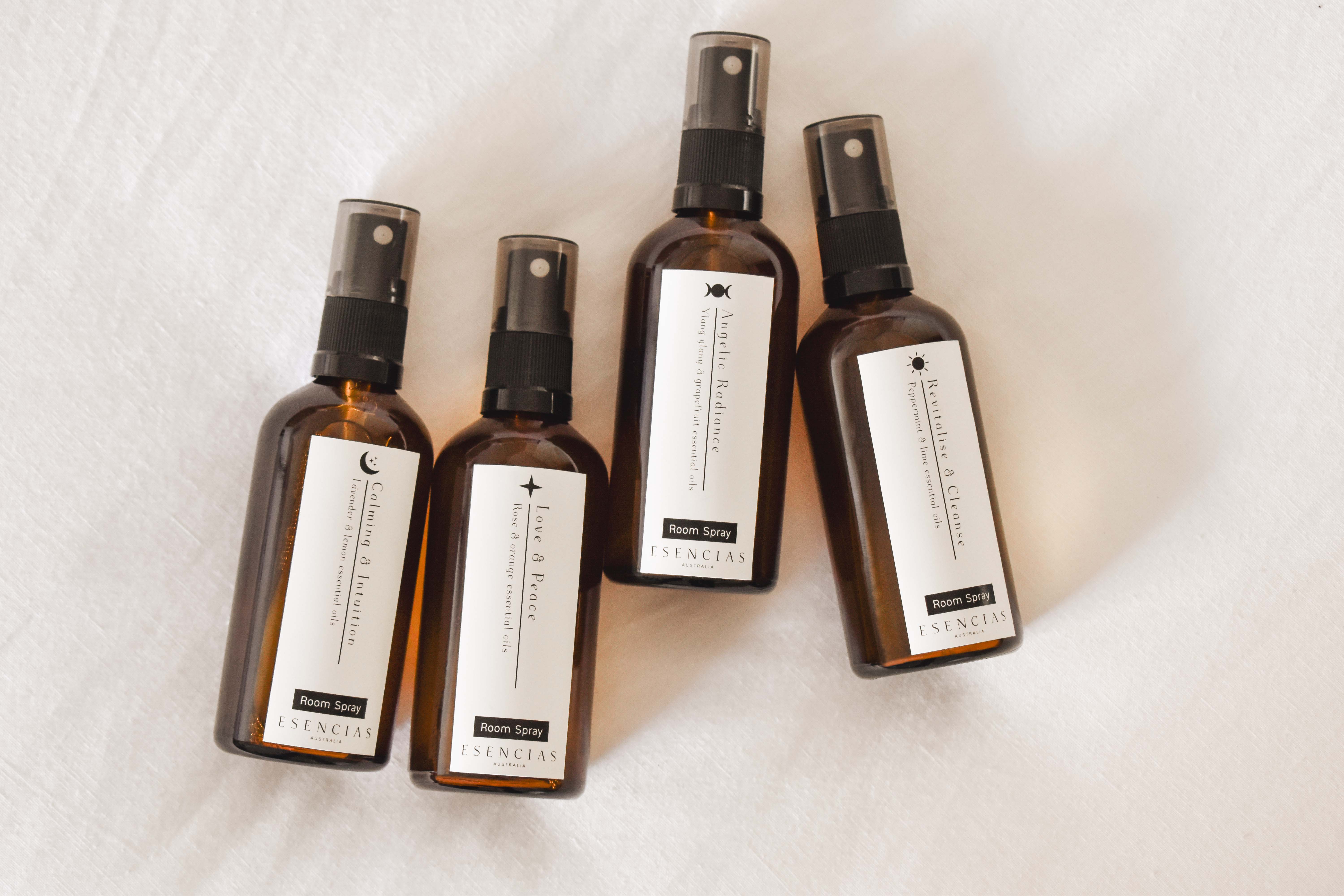 Room sprays displayed on soft white linen in a product-focused image, highlighting their elegant design and clean, minimalist aesthetic.