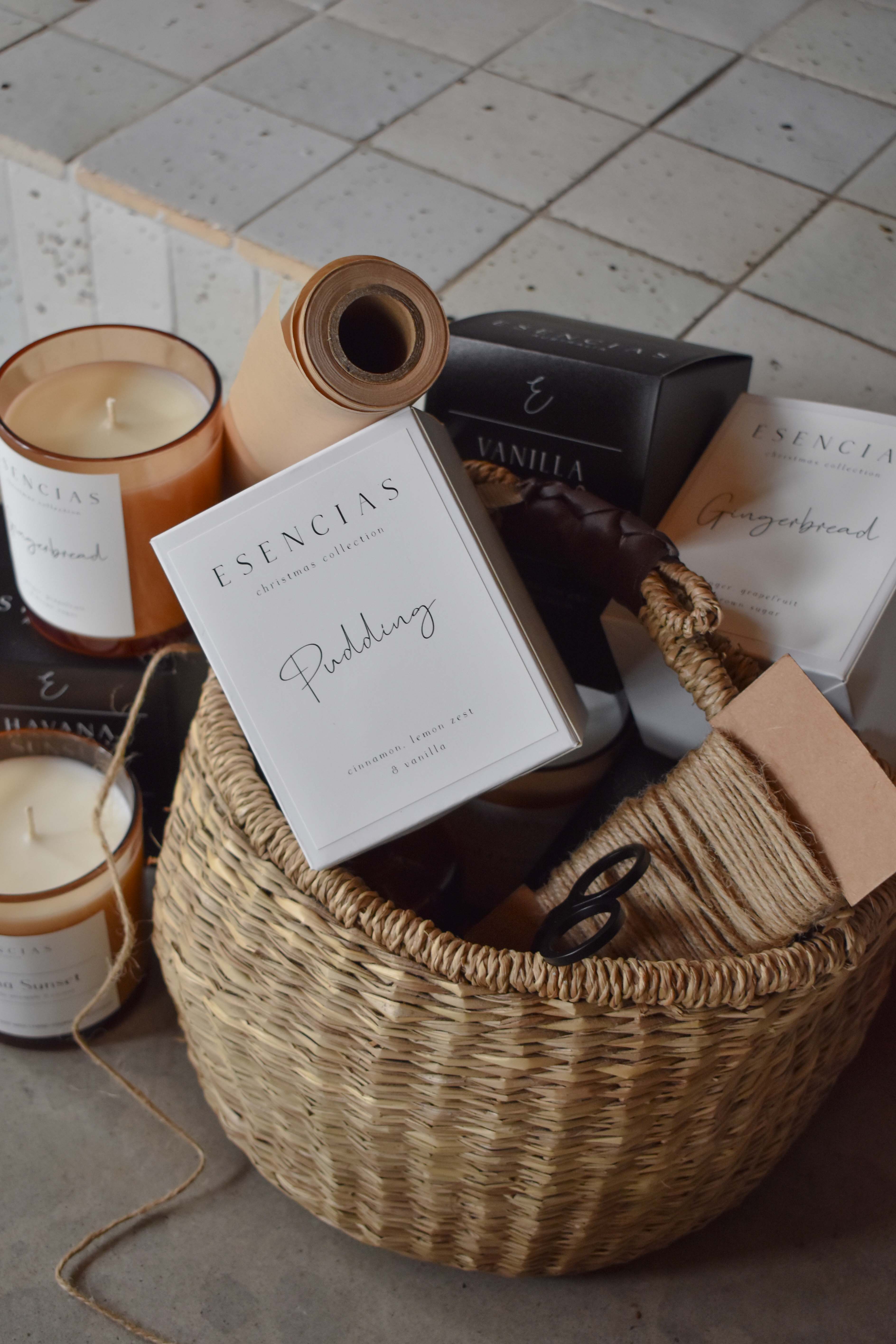 A collection of soy candles in a basket surrounded by packaging supplies, showcasing a behind-the-scenes moment of order preparation.