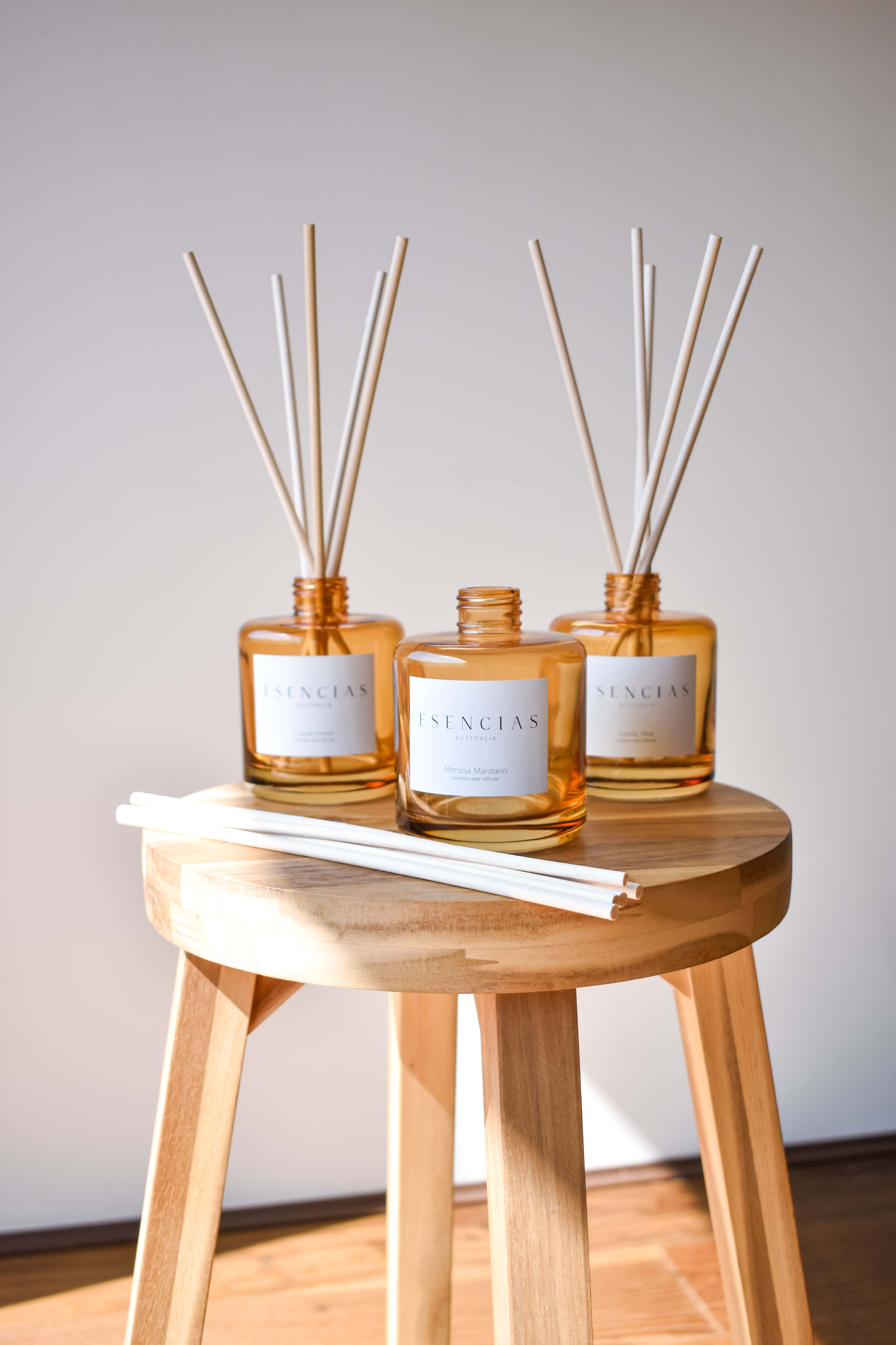 Three reed diffusers in amber jars styled together in a lifestyle display, creating a warm and inviting ambiance.