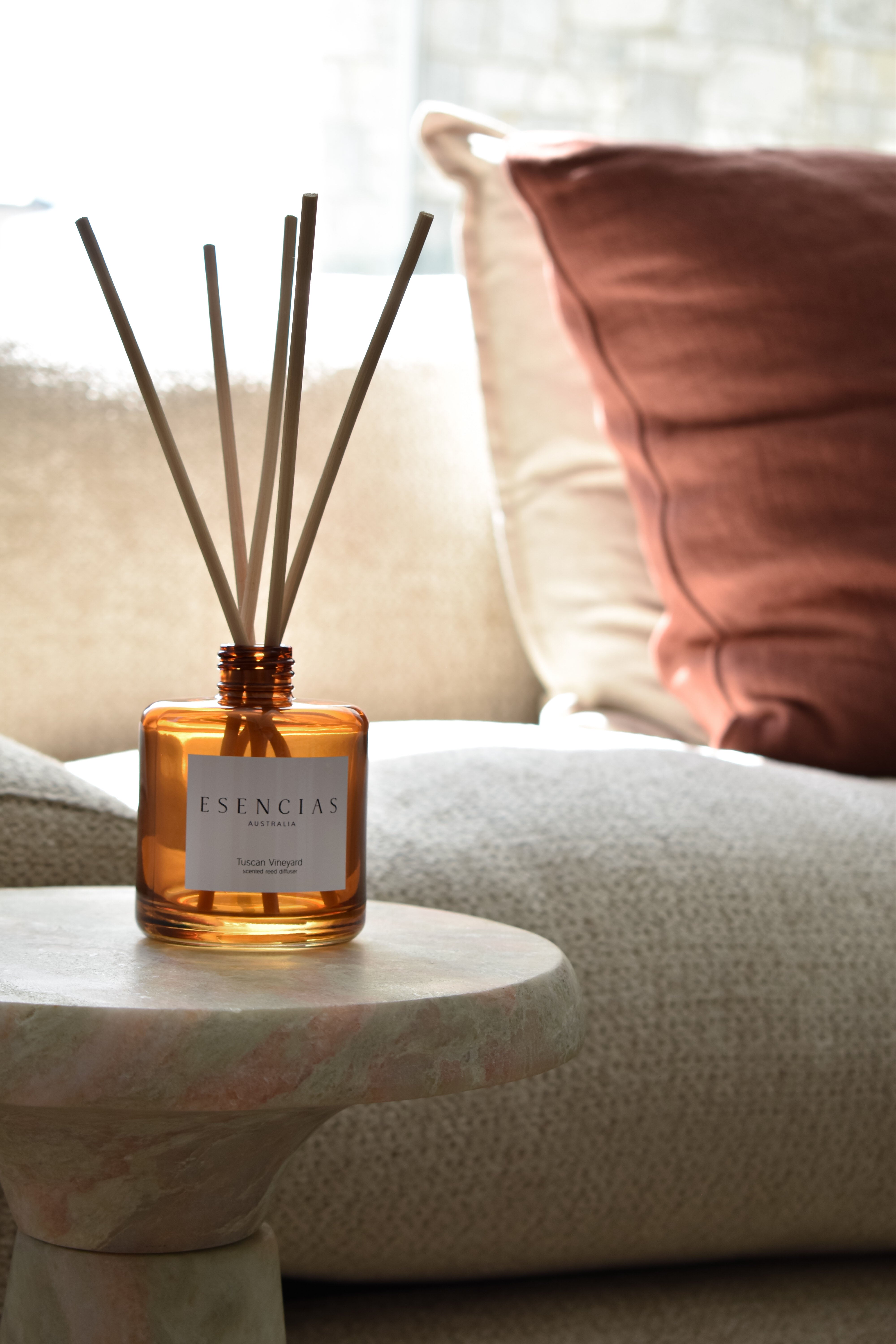 Tuscan Vineyard reed diffuser in signature amber jar styled in a cozy living room lifestyle setting, evoking warm, rustic elegance and inviting ambiance.