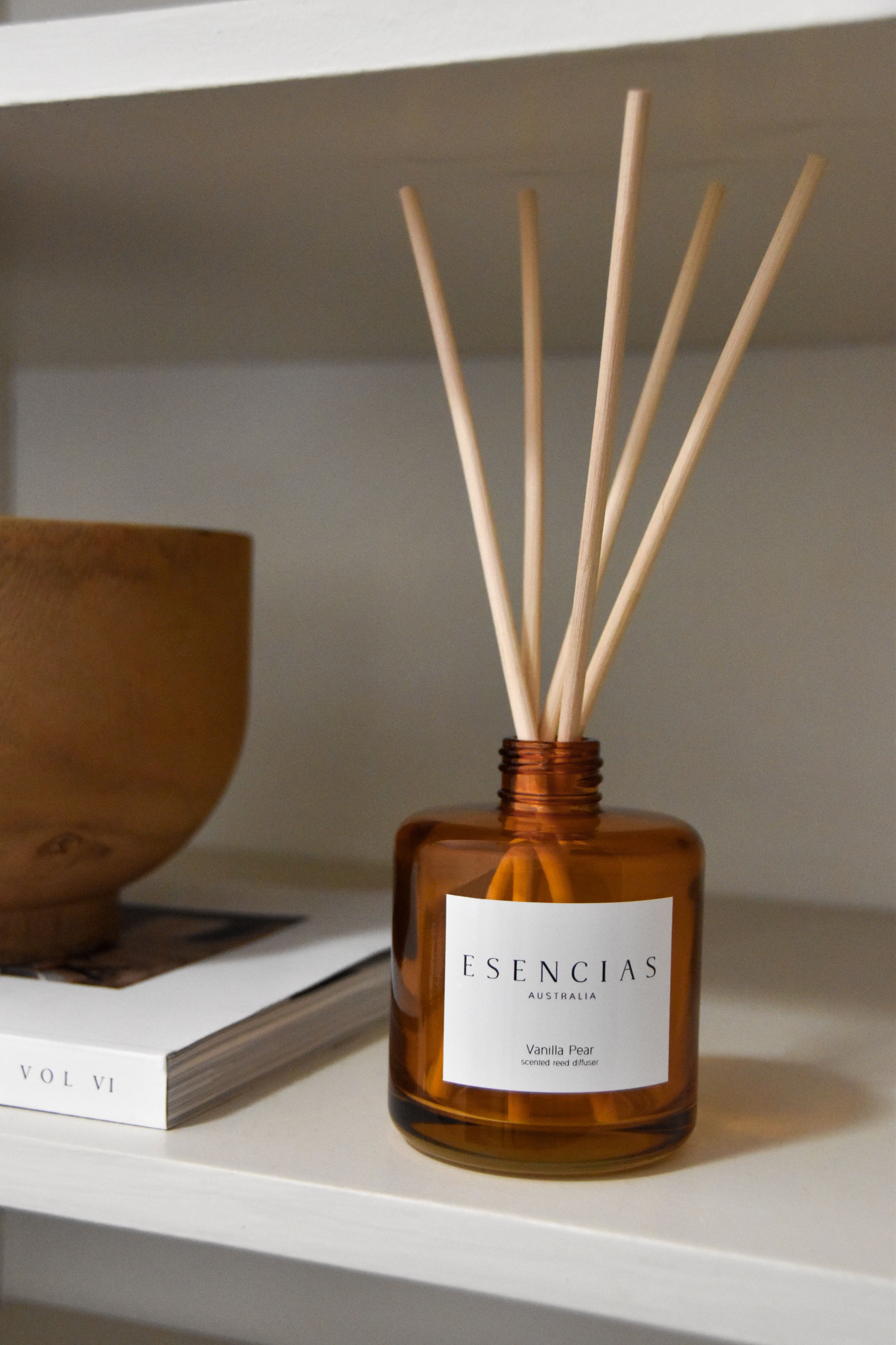 Vanilla Pear reed diffuser in amber jar styled inside on a shelf, creating a cozy and elegant product-focused display.