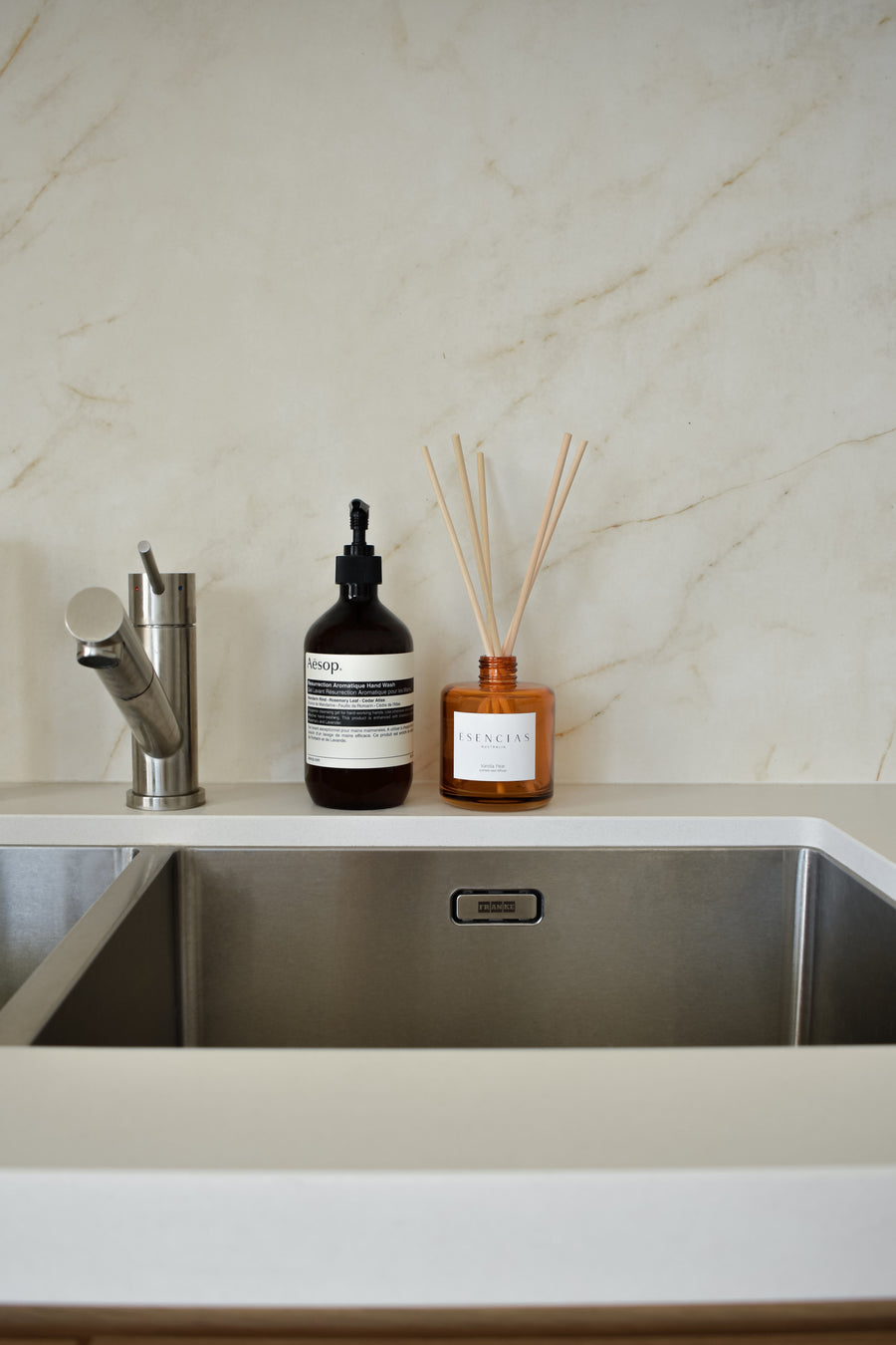 Vanilla Pear reed diffuser in amber jar displayed in a kitchen lifestyle setting, evoking a warm and inviting atmosphere.