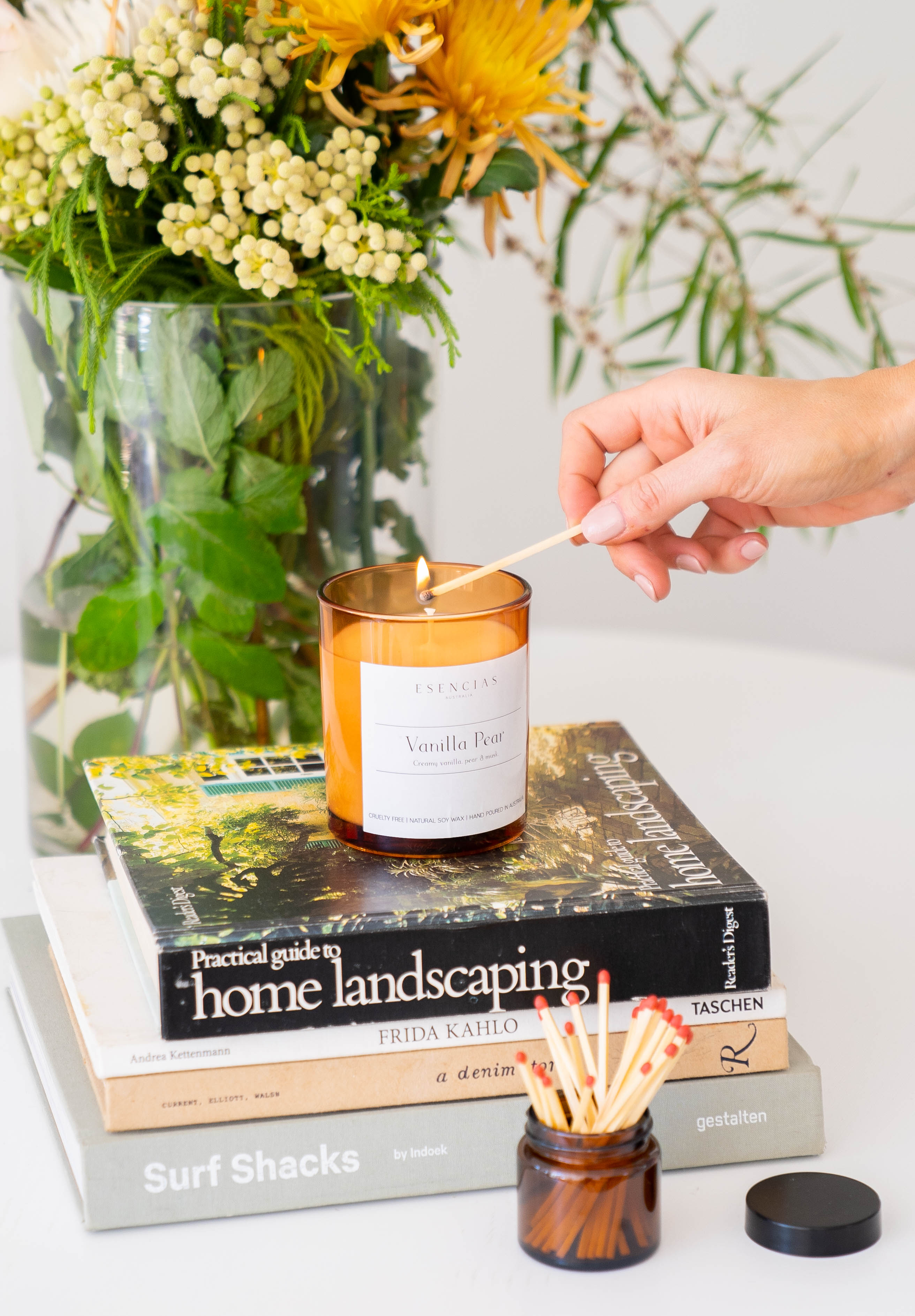 Esencias Signature soy candle being lit with a match