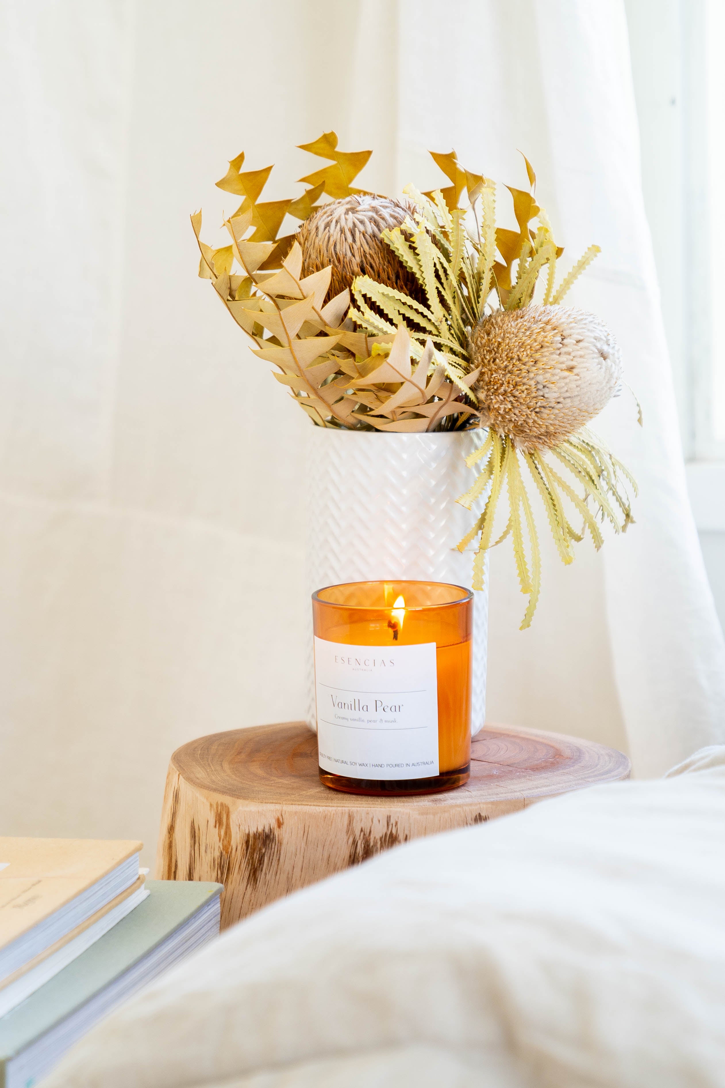 Vanilla Pear soy candle lit in a warm lifestyle setting, softly glowing to create a calming and grounding atmosphere.