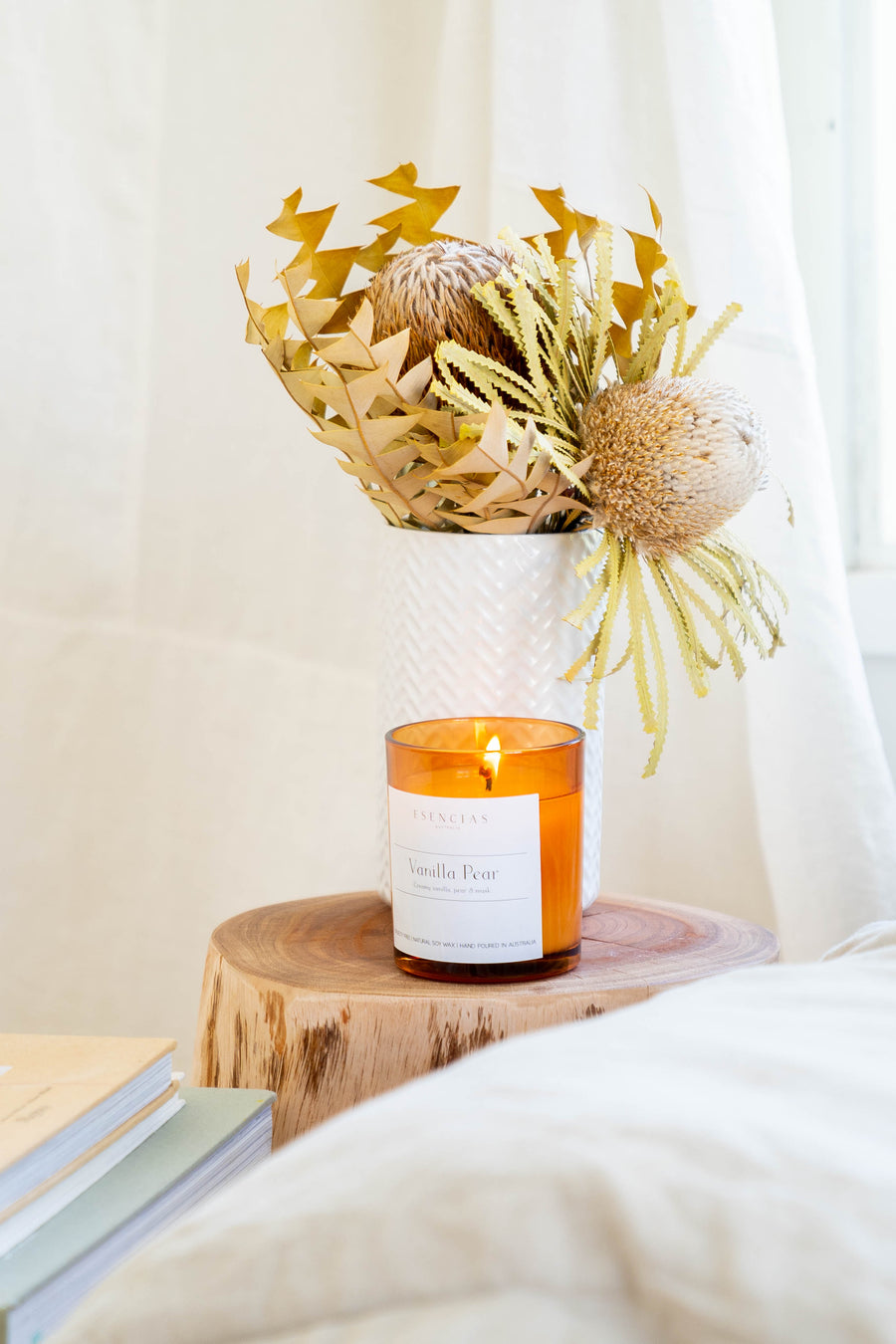 Vanilla Pear soy candle lit in a warm lifestyle setting, softly glowing to create a calming and grounding atmosphere.